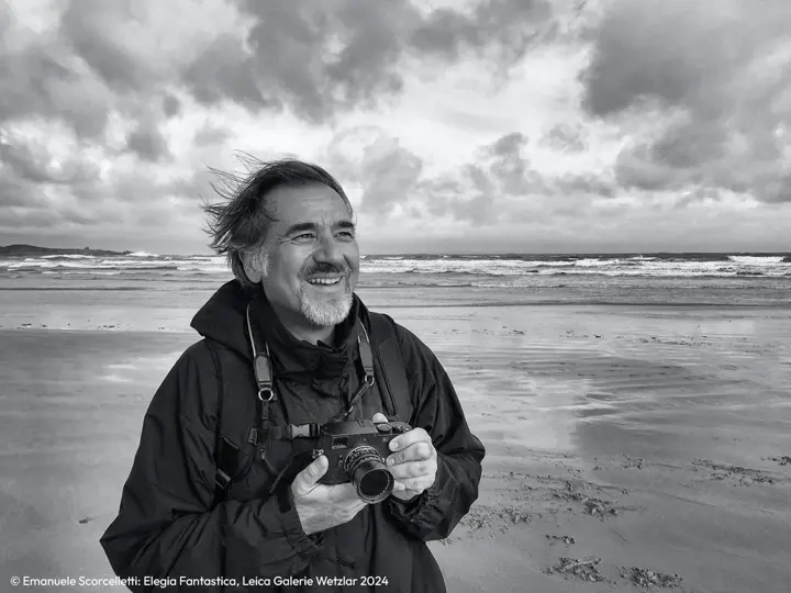 Man with a Leica camera in his hand by the sea
