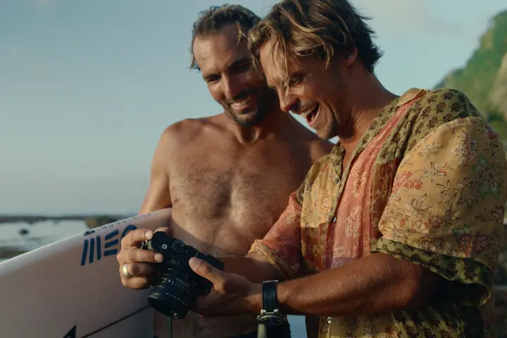 Two surfer checking photos on the camera
