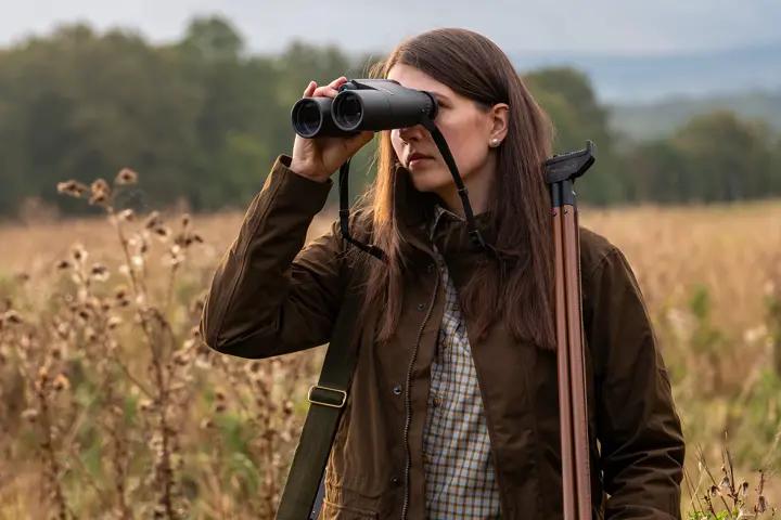 Huntress-observes-a-light-through-Leica-Geovid-R-SE-hunting-binoculars
