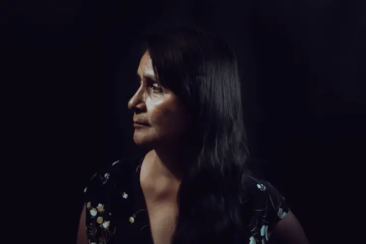Woman looking sideways in front of a black background