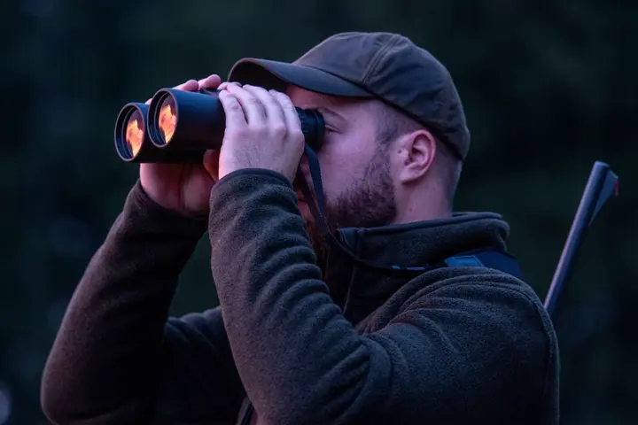Hunter-observes-a-light-through-Geovid-R-hunting-binoculars-at-dusk
