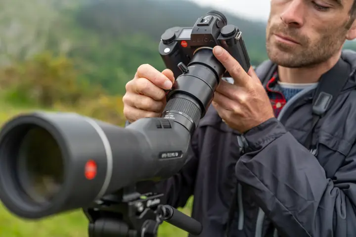Man is digiscoping with his Leica APO-Televid spotting scope