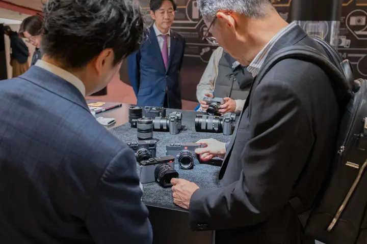 100 years of leica Tokyo, Men looking at Leica cameras