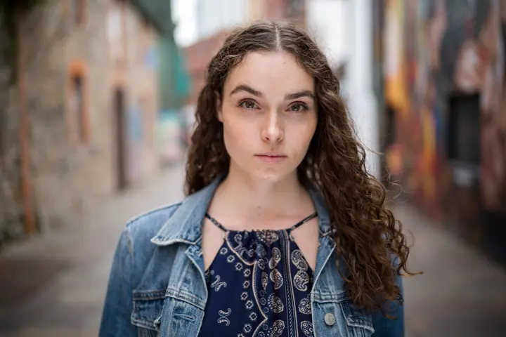 Portrait of a young woman with brown curly hair