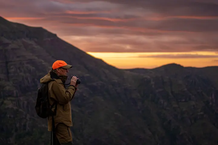 Sunrise in the mountain and a hunter standing in the front