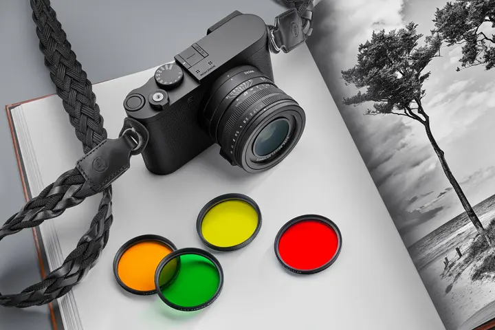 Leica Q3 Monochrom with the colour filters on a book