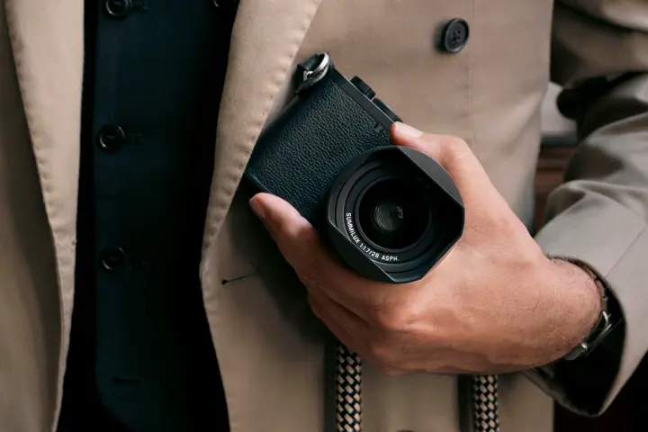 Man in trench coat carrying Q3 Monochrom 