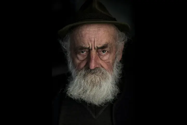 a Gaze of a farmer with a thick white beard 