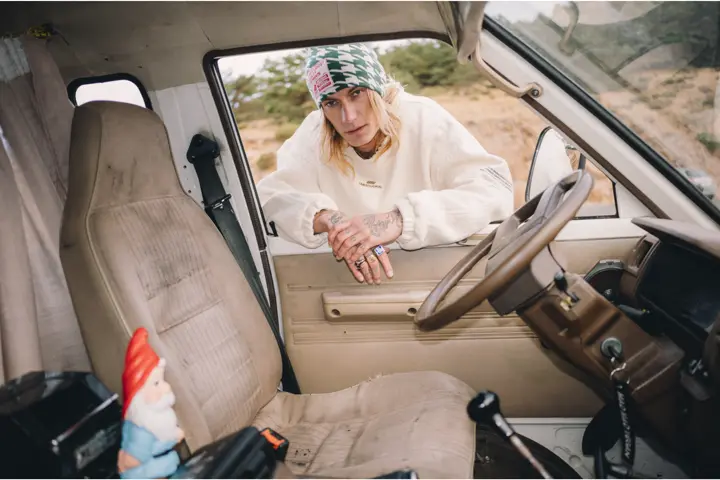 Chico de pie asomándose por la ventana de un coche