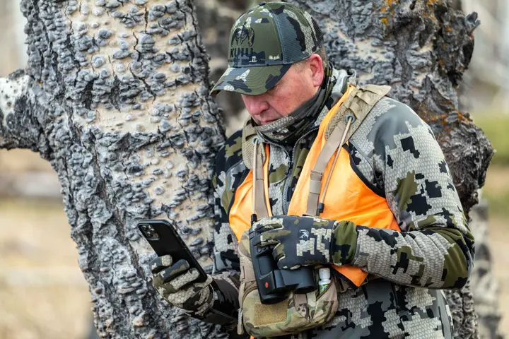 Hunter is looking on his phone with Leica Ballistics App