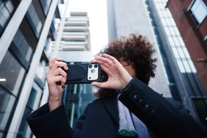 Woman using her iPhone with the LUX Case and the LUX Grip