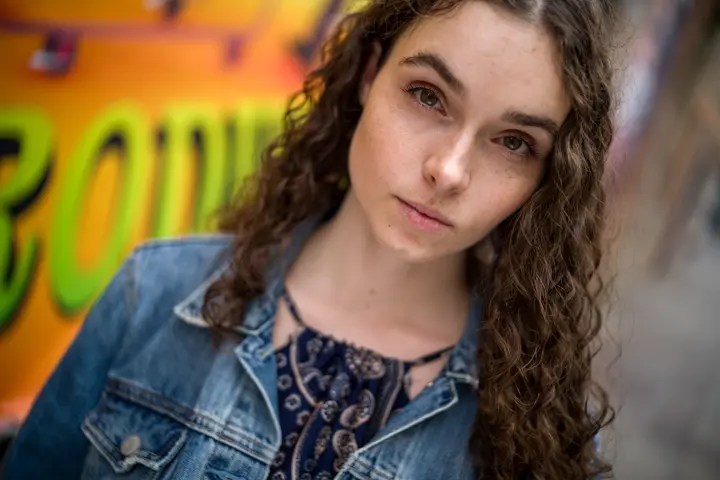 Portrait of a young woman with brown curly hair