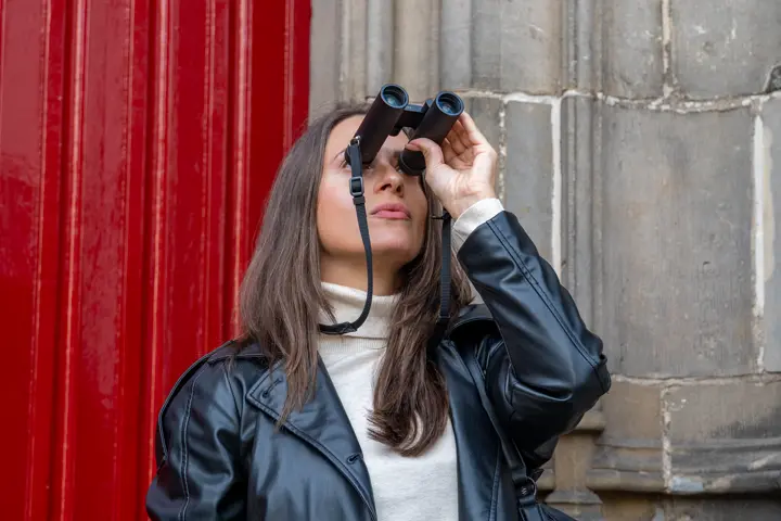 Woman is looking through her Leica Noctivid Compact binos