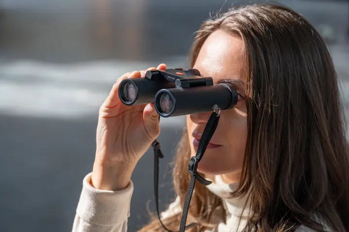 Woman is looking through her Leica Noctivid Compact
