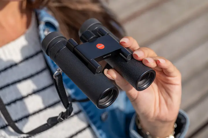 Woman is holding her Leica Noctivid Compact