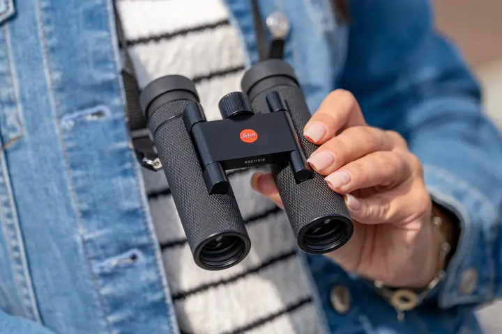 Woman is holding her Leica Noctivid Compact