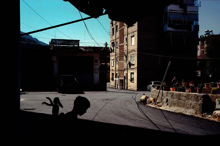 Sur le sol, deux ombres d’enfants se dessinent.