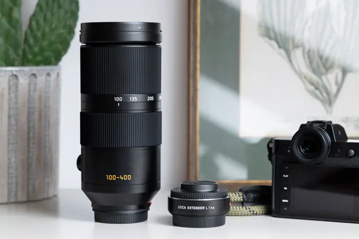 Leica SL camera, Vario-Elmar-SL 100-400 and the Extender L 1.4x next to each other on a desk