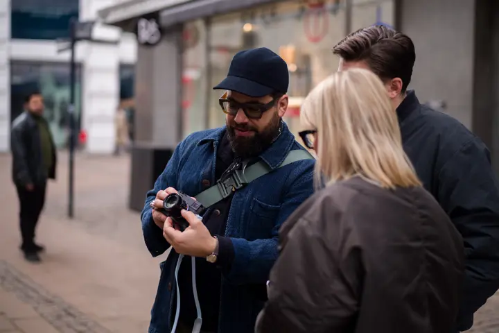 A person is showing people his Leica camera.