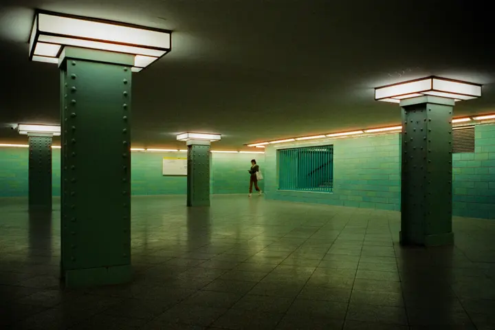 A photograph of a green room with a person walking in the background.