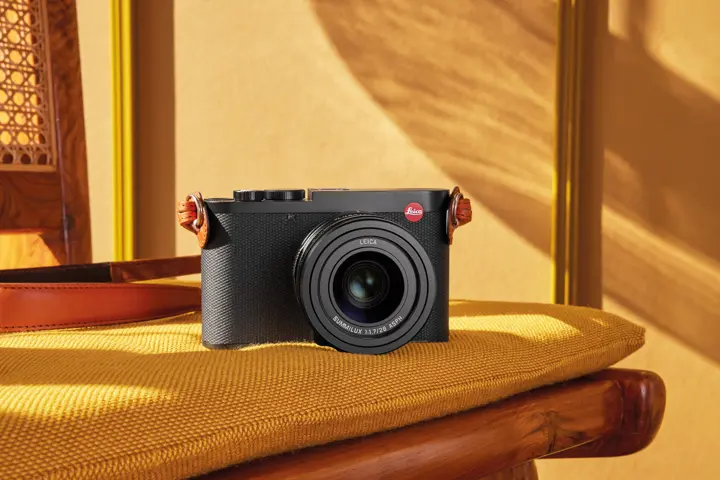 Leica Q3 with a cognac strap on a chair
