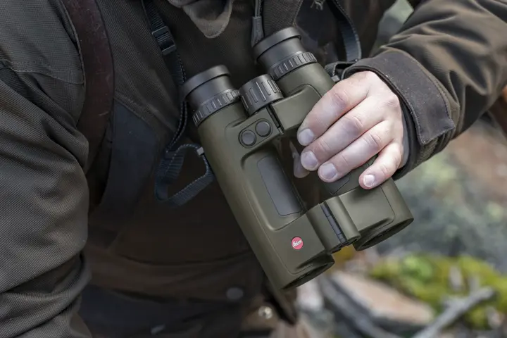 Hunter holding his Leica Geovid Pro in olive green