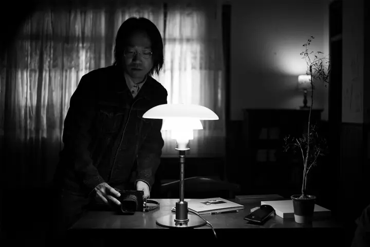 Black-and-white photograph by Xing Lei of a Leica Q3 Monochrom being placed on