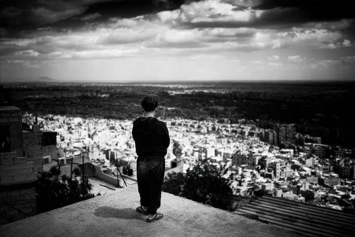 A boy overlooking a city