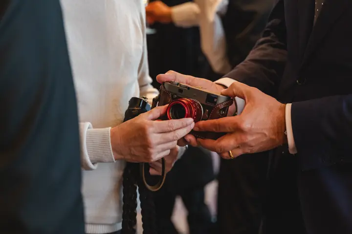 At the Leica Ginza Store Anniversary Dinner, a camera being handed over between guests