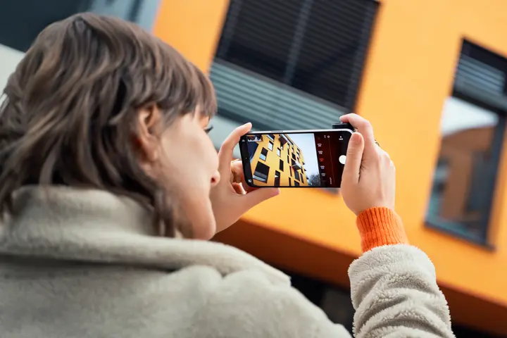 Woman photographing with the Leica LUX Grip