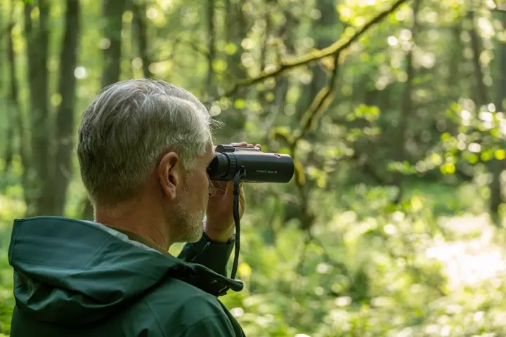 Man is looking through his Leica Trinovid