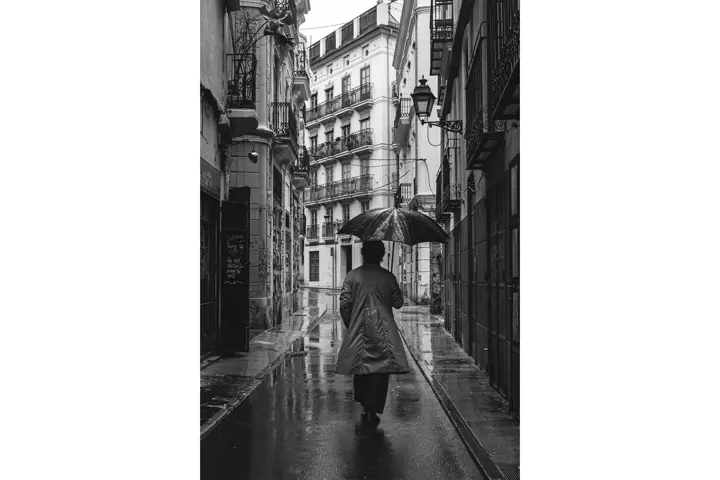 Persona caminando por una ciudad mientras llueve