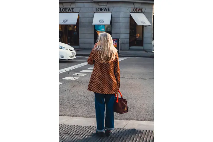 Mujer de espaldas esperando para cruzar una calle