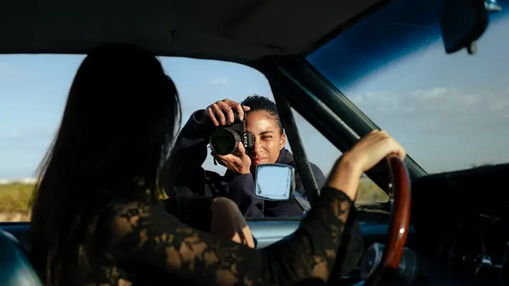 Femme photographiant un mannequin assis dans une voiture