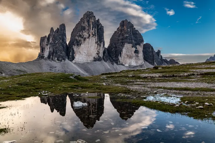The Tre Cime di Lavaredo in the Dolomites reflected in a mountain pool.