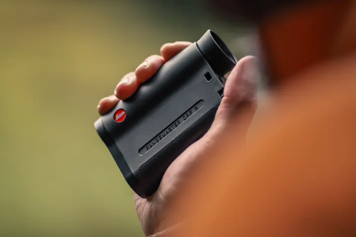Close-up–of–a–person–using–a–Leica–Rangemaster–CRF–compact–rangefinder–outdoors