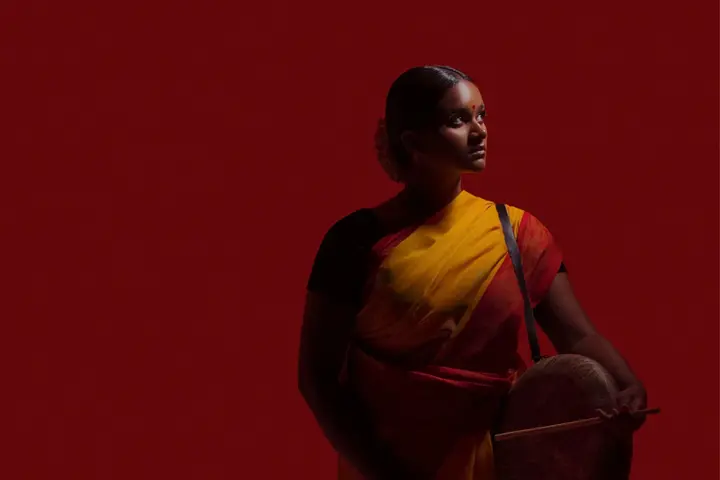 A woman is standing in front of a red background