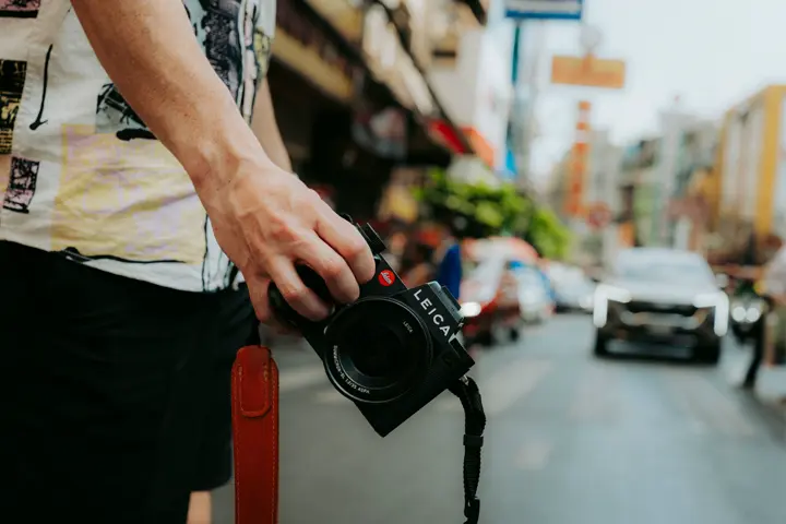 Photographer Phillipp Reinhard passing a street in Thailand with the Leica SL3 in his hands