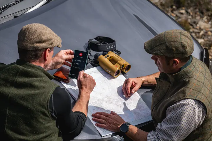 Two hunter are looking at the smartphone with the Leica Ballistics App