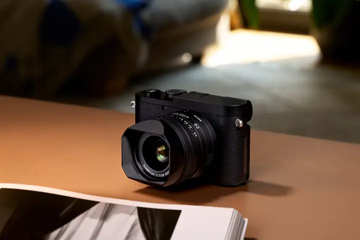 Leica Q compact camera — Leica Q camera with fixed 28 mm Summilux lens displayed on a table in a softly lit interior.