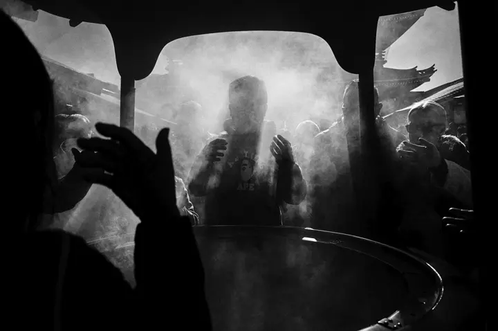 Temple Visitors Bathing in Incense Smoke