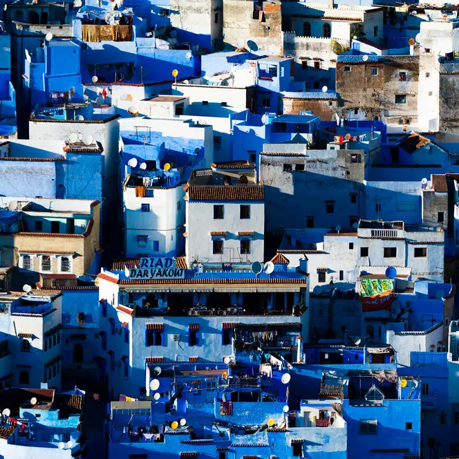 A cityscape with many blue and white houses standing close together.