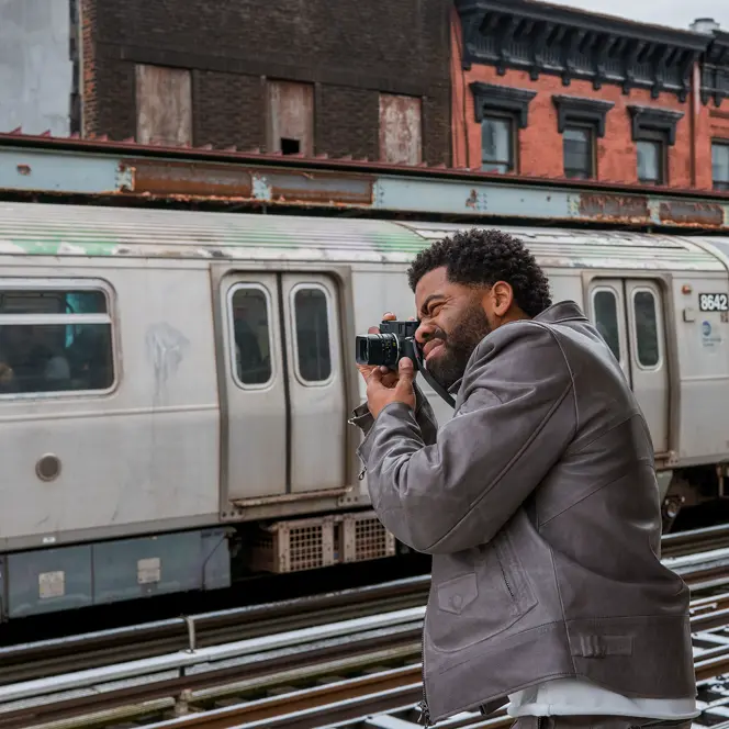 Man photographs a train with a Leica M11