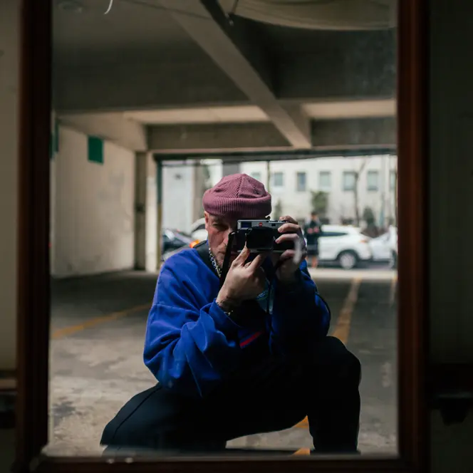 A man takes a picture of himself in a mirror in a garage.