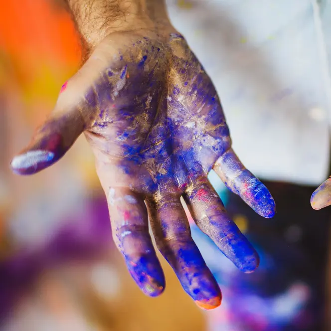 Close-up of hands smeared with blue paint.