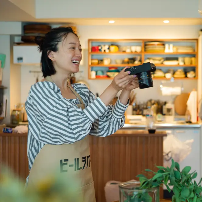 Smiling woman taking a picture of a plant in a food store.
