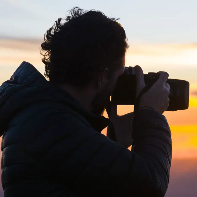 A photographer takes a photo of the sunset.