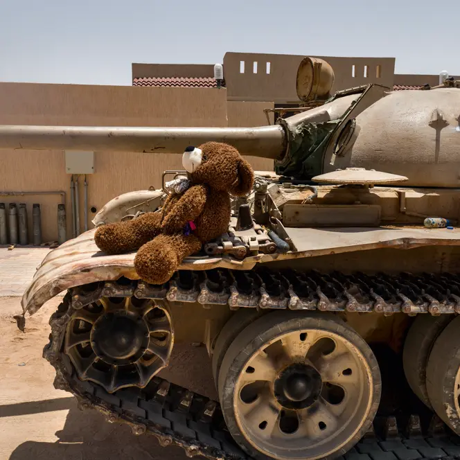 Teddy bear sitting on a tank