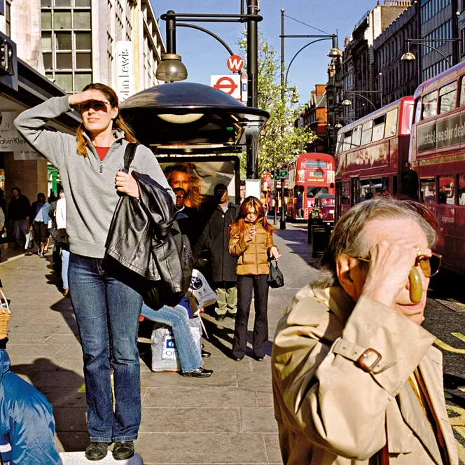 A woman who was standing on a bench, appearing to be looking for something and other people