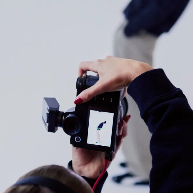 Photographer from behind in a photo studio photographing a man